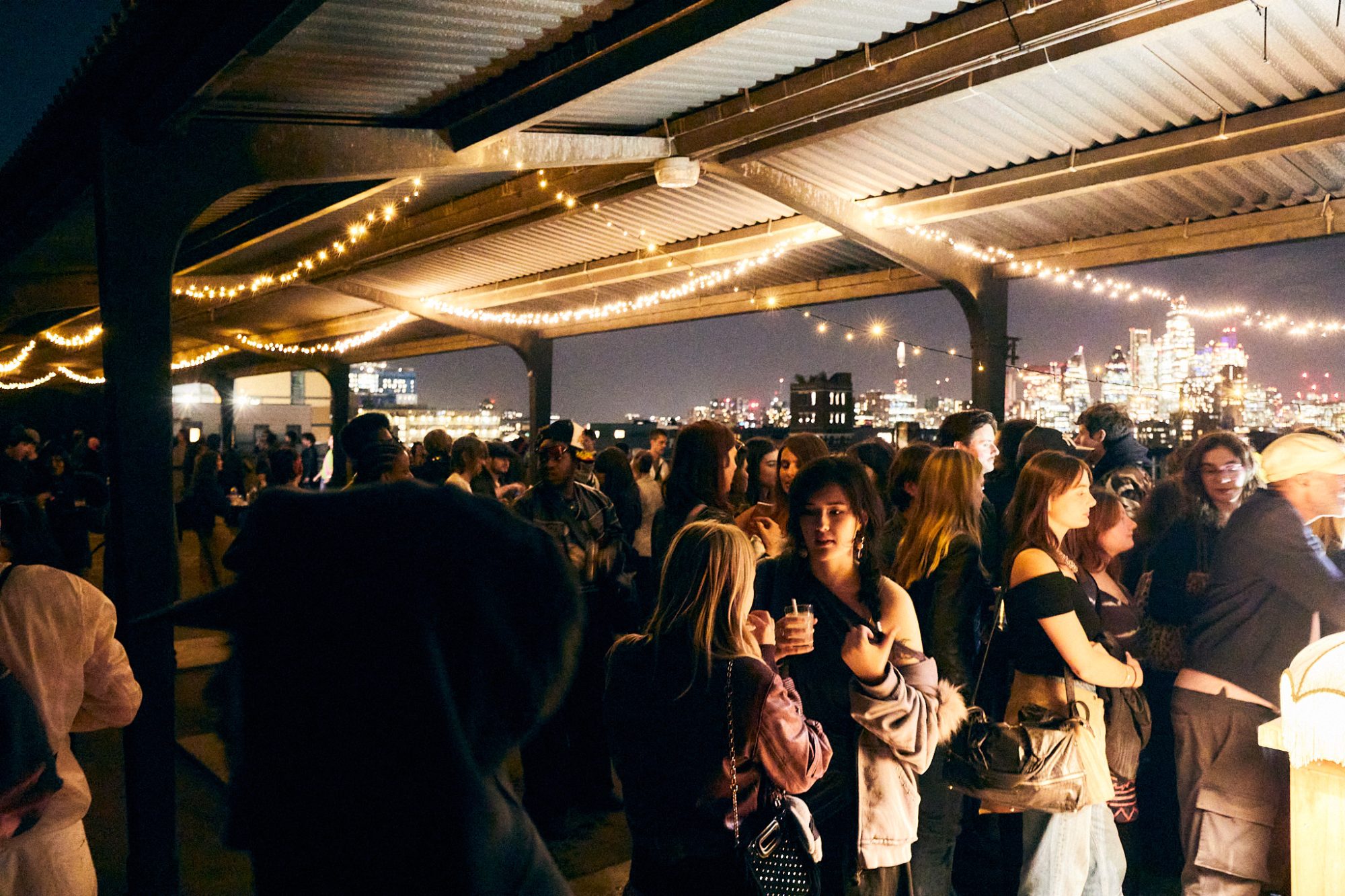 The crowd under festoon lights at the GLISTER afterparty